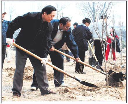 图为《经济日报》社长武春河（左）正在植树。